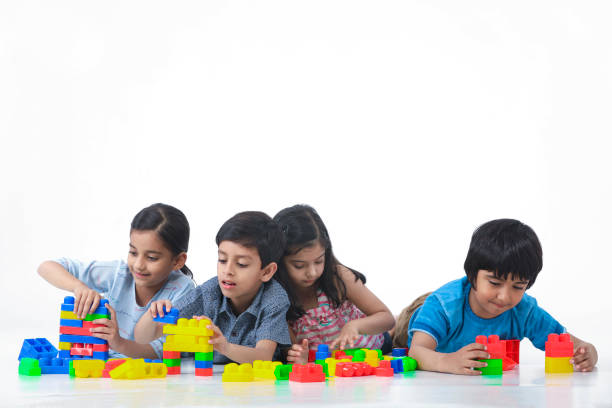 Indian, Asian Kids Playing With Toy Blocks Against White Background